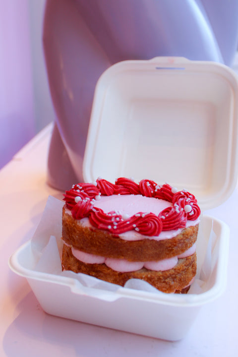 Een bento cakeje met frambozen smaak. in roze en rode kleuren in een schattig bento / hamburger doosje verpakt.