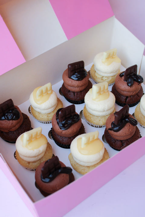 Box met 12 mini cupcakes met witte en pure chocolade topping, chocolade reepje en saus